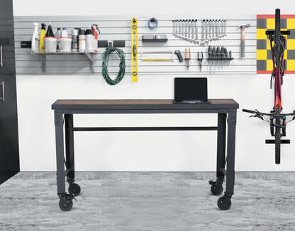 Duramax rolling worktable with wooden top and caster wheels in industrial workshop setting, featuring metal frame and tools on wall.
