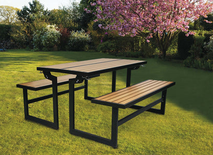 Duramax Ashton Convertible Table Bench in picnic table mode set on a lush green backyard lawn under blooming trees.