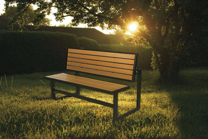 Duramax Ashton Convertible Table Bench in a sunny backyard, showcasing its sturdy steel frame and wooden slats against a lush garden backdrop.